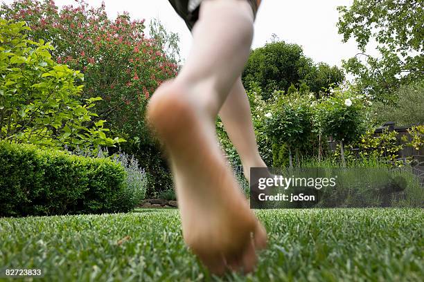 close-up of boys feet running on lawn - boy barefoot rear view stock-fotos und bilder