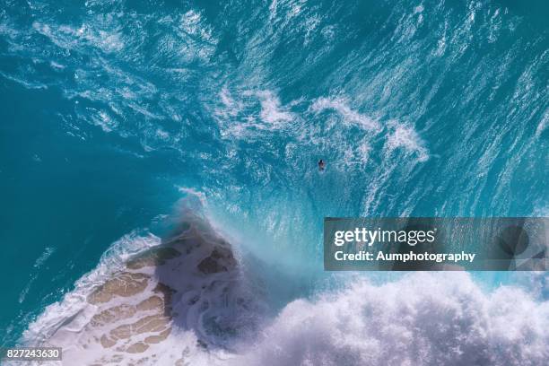 top view of huge ocean waves at kelingking beach, nusa penida island, indonesia. - waterline stock pictures, royalty-free photos & images