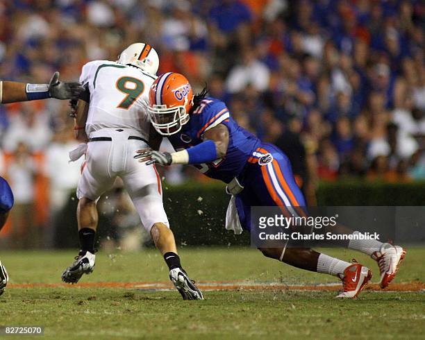 Quarterback Robert Marve of the Miami Hurricanes runs for a few yards before being tackled by linebacker Brandon Spikes of the Florida Gators on...