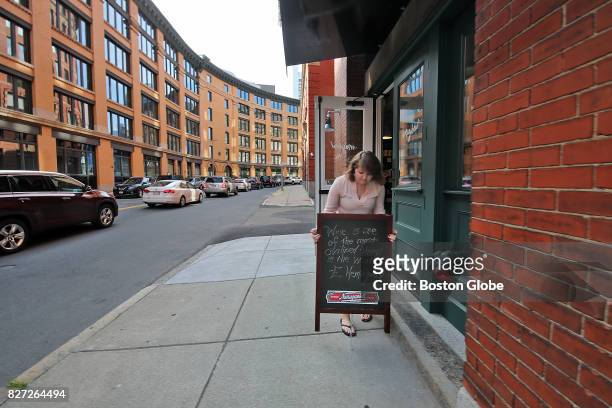 Chandler Parker puts out a sign announcing a wine tasting in front of Mayhew, a retail wine shop across from the new Amazon headquarters in South...