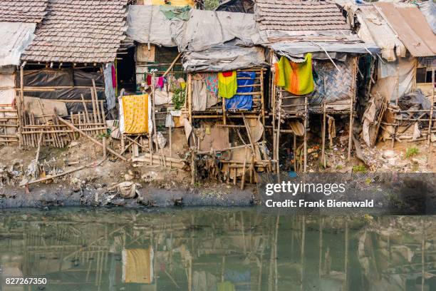 The dwellings and huts in Topsia slum are located at a dirty river.