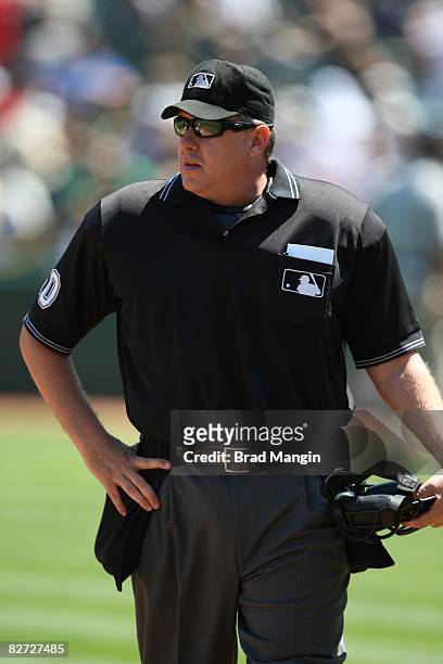 Home-plate umpire Paul Emmel stands on the field during the game between the Oakland Athletics and the Minnesota Twins at the McAfee Coliseum in...