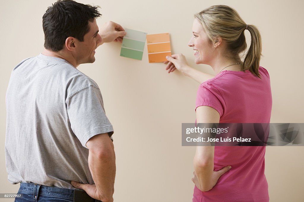 Young couple comparing paint samples