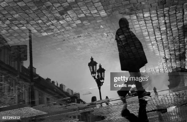 walking man during rush hour - cobblestone puddle stock pictures, royalty-free photos & images