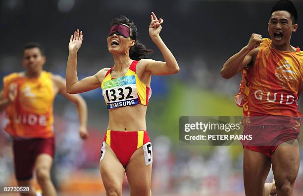 Partially-sighted runner Wu Chunmiao of China wins gold with her guide in the final of the 100m T11 final A during the 2008 Beijing Paralympic Games...