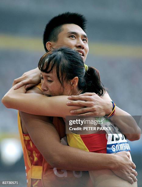 Partially sighted runner Wu Chunmiao of China is hugged by her guide after she won gold in the final of the 100m T11 final A during the 2008 Beijing...