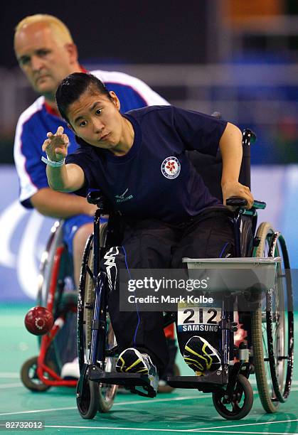 Hoi Ying Karen Kwok of Hong Kong is watched by Nigel Murray of Great Britain as she takes a throw in the gold medal Mixed Individual BC2 Boccia match...