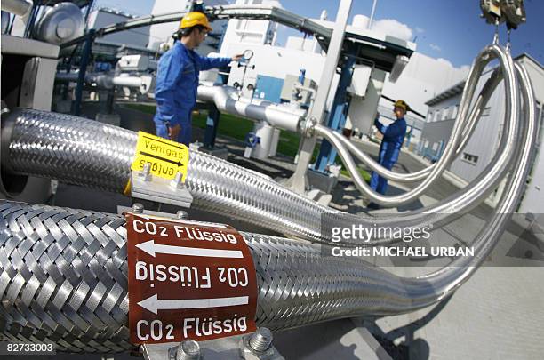 Two employees work on pipes carrying liquid CO2 on September 08, 2008 at the "Schwarze Pumpe" power station run by Europe's biggest power company...