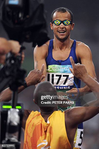 Partially-sighted runner Lucas Prado of Brazil celebrates with his guide after his victory in the A final of the 100m T11 during the 2008 Beijing...