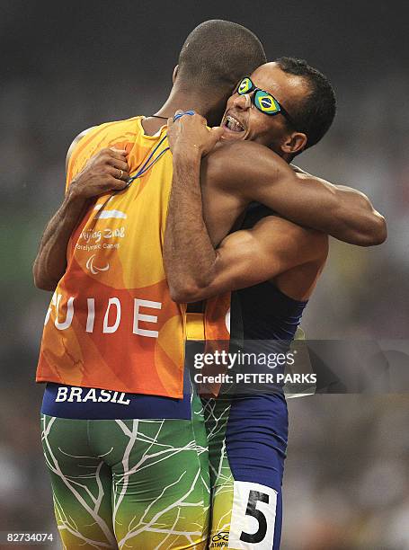 Partially-sighted runner Lucas Prado of Brazil celebrates with his guide as his victory in the A final of the 100m T11 during the 2008 Beijing...