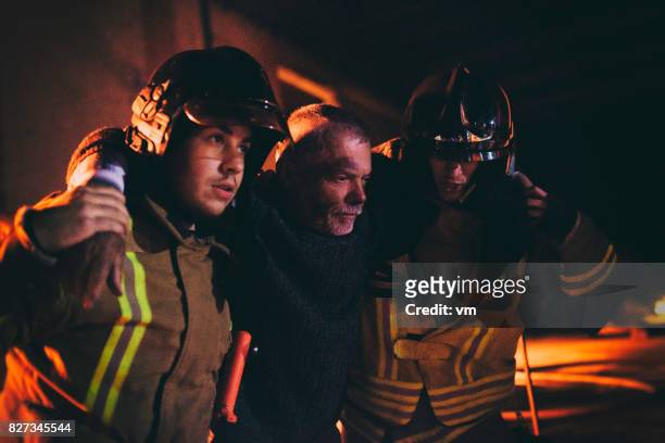 bomberos ayudando a un hombre - burn injury fotografías e imágenes de stock