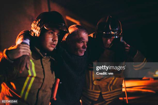 firefighters helping a man - firemen at work stock pictures, royalty-free photos & images