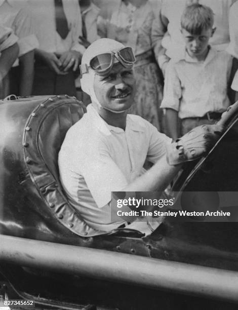 Three-time Indianapolis 500 winner, Wilbur Shaw poses for a portrait from inside his race car, circa 1937.