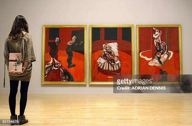 Visitor admires a triptych by Irish born British artist Francis Bacon entitled "Three Studies for a Crucifixion 1962" at the Tate Britain gallery in...
