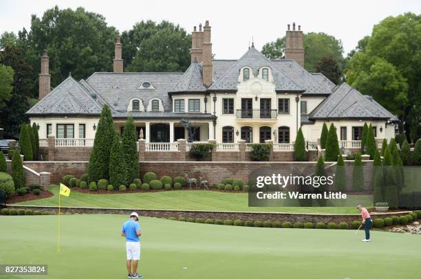Rory McIlroy of Northern Ireland putts as caddie Harry Diamond looks on during a practice round prior to the 2017 PGA Championship at Quail Hollow...