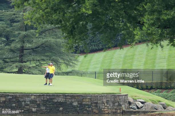 Yuta Ikeda of Japan waits on a green during a practice round prior to the 2017 PGA Championship at Quail Hollow Club on August 7, 2017 in Charlotte,...