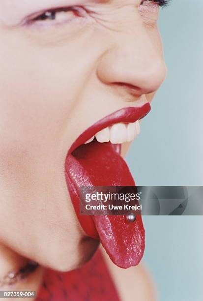 teenage girl (17-19) poking out tongue to reveal piercing, close-up - pierced stock pictures, royalty-free photos & images