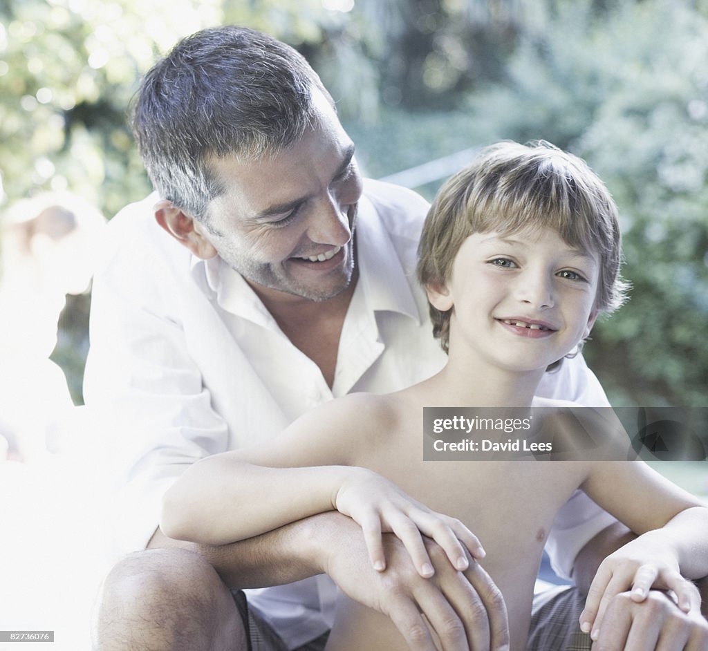 Father and son (4-6) portrait, smiling