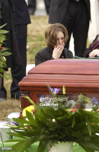 Shannon Spann kneels graveside as Marines conduct a full honors funeral December 10, 2001 at Arlington National Cemetery for her husband, CIA agent...