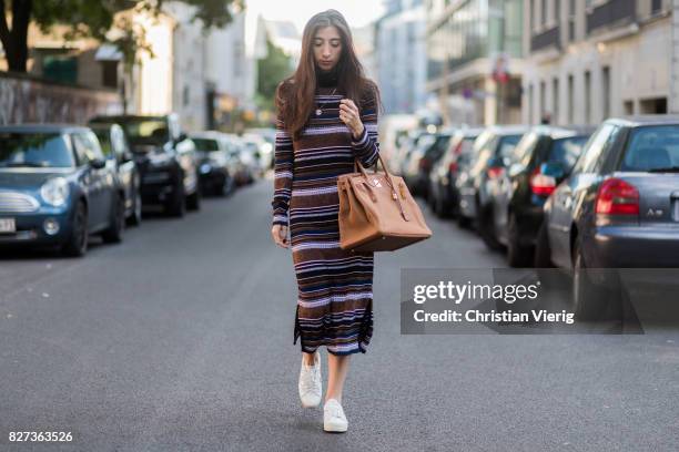 Nadja Ali wearing striped Lala Berlin dress, a brown Hermes bag, white Saint Laurent sneakers, Chanel necklace on August 7, 2017 in Berlin, Germany.