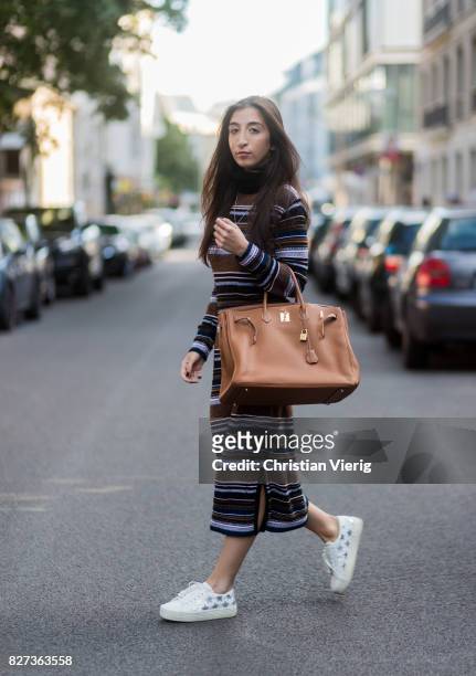 Nadja Ali wearing striped Lala Berlin dress, a brown Hermes bag, white Saint Laurent sneakers, Chanel necklace on August 7, 2017 in Berlin, Germany.