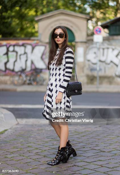 Nadja Ali wearing a white black MSGM dress, black Lala Berlin boots, black Chanel bag, Celine sunglasses, Chanel necklace on August 7, 2017 in...