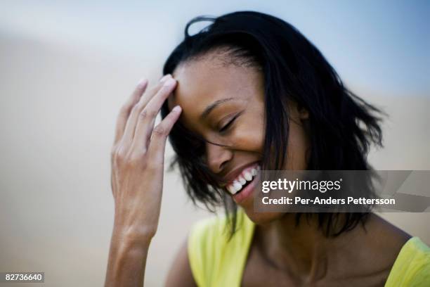 young woman in dress standing in sand dunes, smili - namibia women stock pictures, royalty-free photos & images