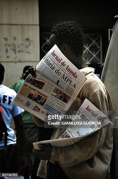 An Angolan newspaper street seller stands in the street on September 9, 2008 selling copies of the national paper announcing the victory of the...