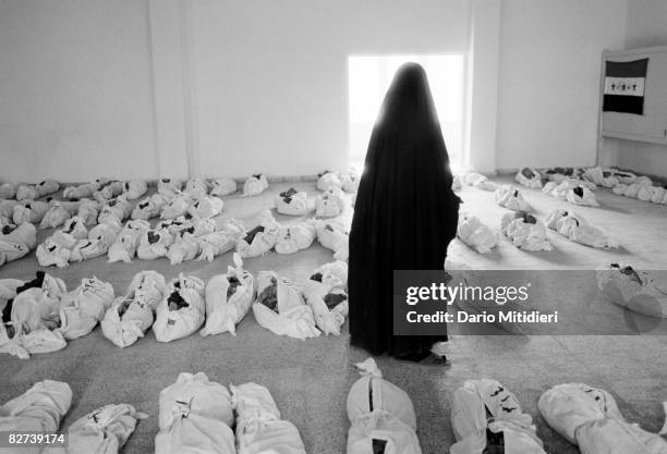 Woman searching for her missing husband looks at corpses recovered from a mass grave near Al Musayyib, 100 km south of Baghdad in May, 2003. Up to...