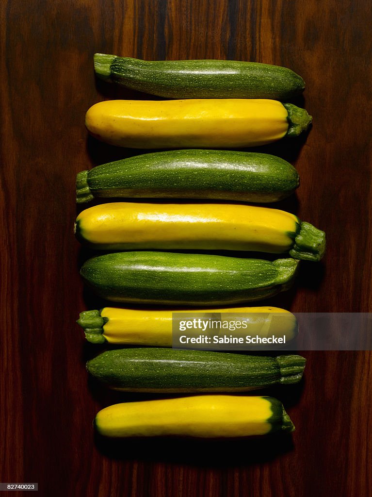 Green and yellow squash on wood