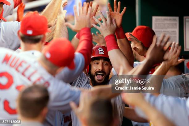 Matt Carpenter of the St. Louis Cardinals is congratulated by teammates in the dugout after hitting a three-run home run during the 4th inning of the...