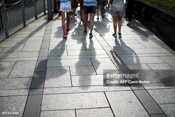 In this photograph taken on August 1 Chinese women walk in the Lujiazui Financial District in Pudong in Shanghai. A wildly popular drama likened to...