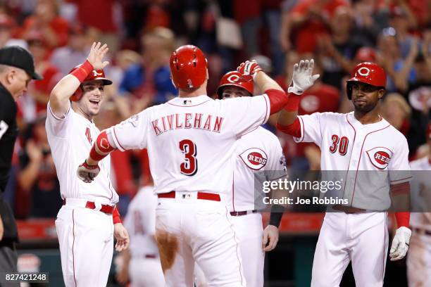 Patrick Kivlehan of the Cincinnati Reds is congratulated by Scooter Gennett and Arismendy Alcantara after hitting a grand slam home run in the eighth...