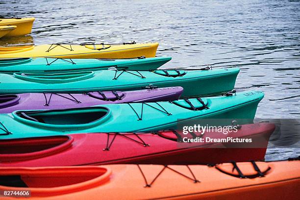row of kayaks in water - 2001 dream group stockfoto's en -beelden