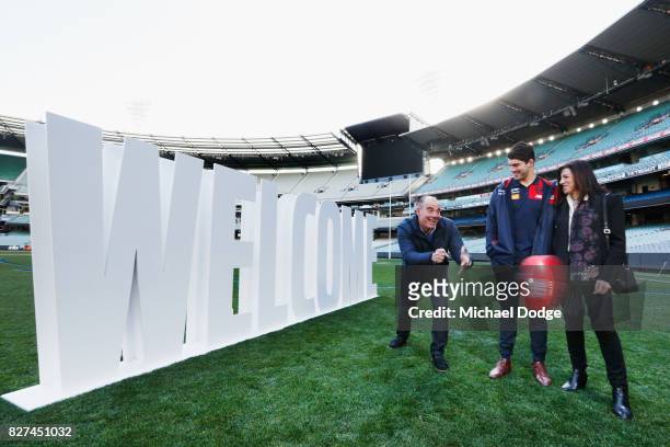Christian Petracca watches his dad Tony handpass the ball with mum Elvira during the Melbourne Demons AFL Welcome Game Launch media opportunity at...