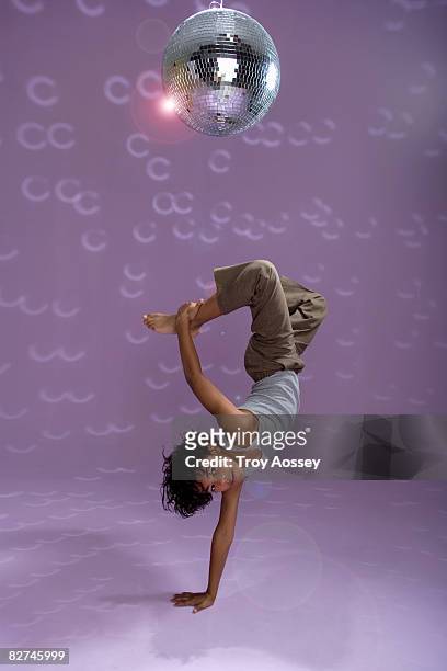 young boy doing a dance move under disco ball - boys dancing stock pictures, royalty-free photos & images
