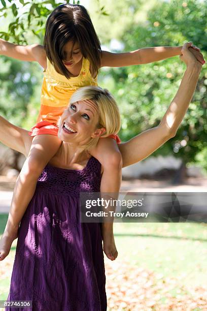 mother carrying child on shoulders - troy bond stock pictures, royalty-free photos & images