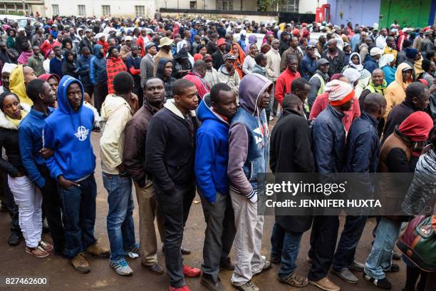 People wait in line to cast their ballot in the general elections at a polling station in the Rift Valley town of Eldoret, Kenya, on August 8, 2017....