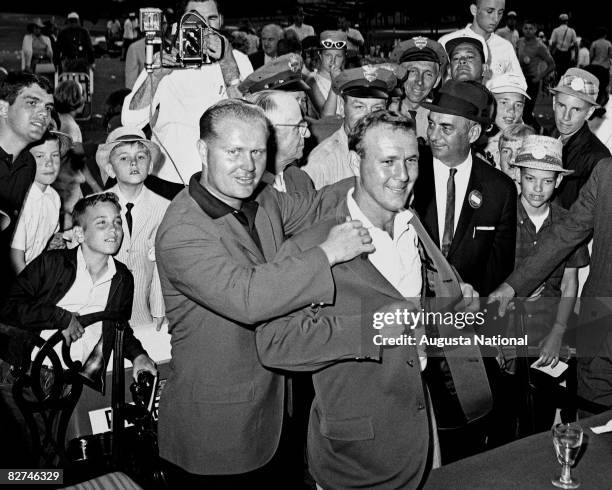 Jack Nicklaus presents Arnold Palmer with the green jacket during the Presentation Ceremony at the 1964 Masters Tournament at Augusta National Golf...