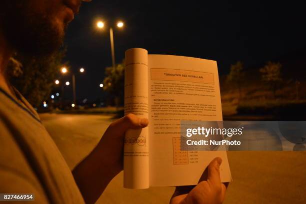 Man shows an educational book in Ankara, Turkey on August 07, 2017. The Turkish government takes a giant step in Turkey's education system with...