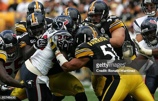 Running back Steve Slaton of the Houston Texans is tackled by Nick Eason, Lawrence Timmons, James Harrison, Travis Kirschke and James Farrior of the...
