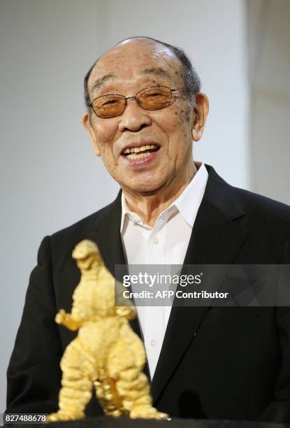 In this picture taken on July 19 Japanese actor Haruo Nakajima speaks behind a gold statue of Godzilla at a Godzilla exhibition in Tokyo. Nakajima,...