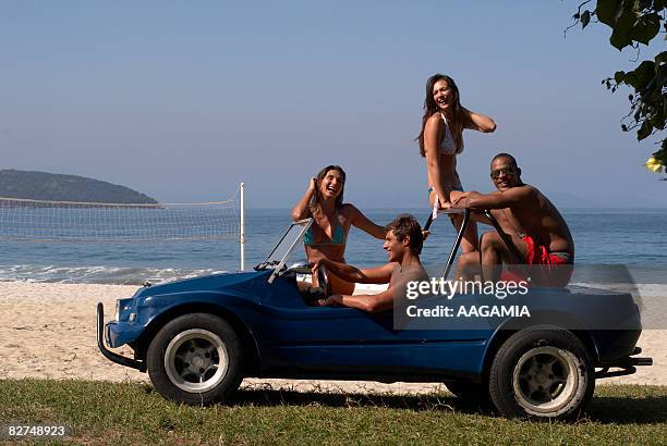 two young couples in a buggy riding on seaside - ancine and car stock pictures, royalty-free photos & images