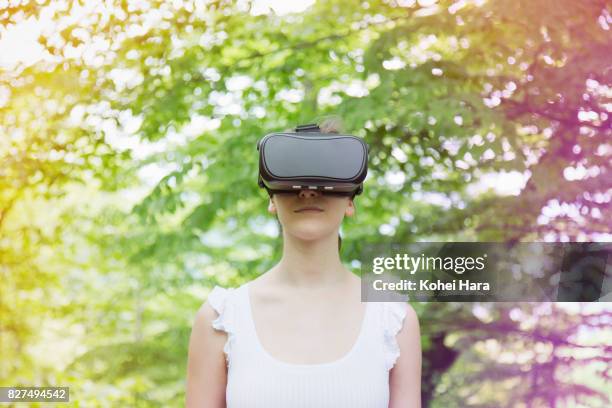 woman using virtual reality headset in visionary forest - looking through an object stock pictures, royalty-free photos & images