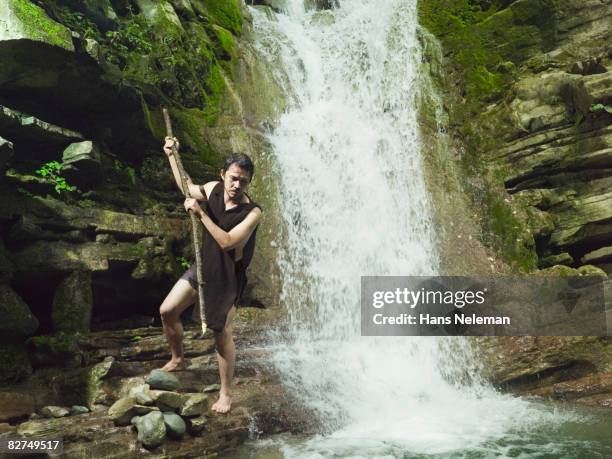 man spearing fish in a waterfall - man spear fishing stock pictures, royalty-free photos & images