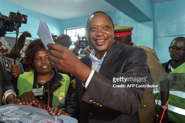 Kenya's incumbent President Uhuru Kenyatta holds a ballot paper at the polling station, during the August 8, 2017 presidential election in Gatundu,...