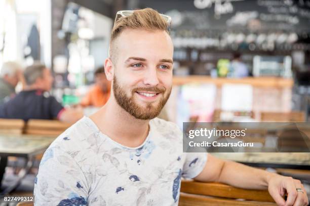 schönen jungen erwachsenen mann in der bar - gebrochener arm stock-fotos und bilder