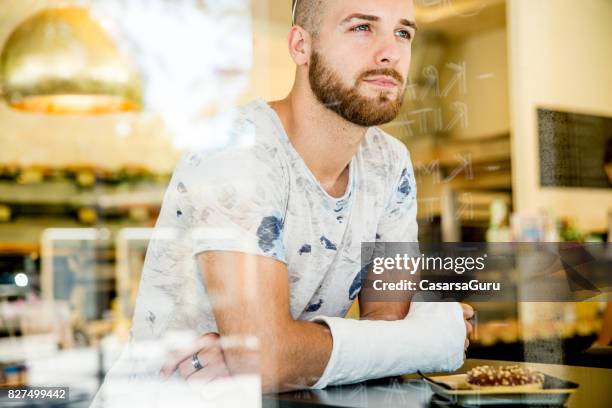 young adult handsome man in bar - broken arm stock pictures, royalty-free photos & images