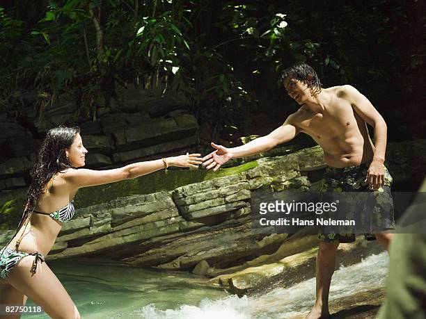 man leading his friend into the water - las posas foto e immagini stock