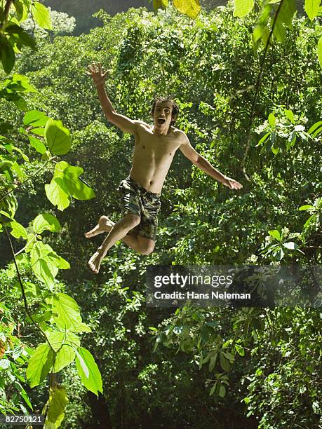 young man jumping into the forest - las posas foto e immagini stock